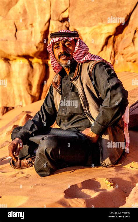 A Bedouin Man Sits Against A Backdrop Of The Jordanian Desert At Wadi