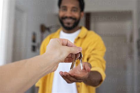 Hand Of Real Estate Agent Giving House Keys To Man Stock Photo