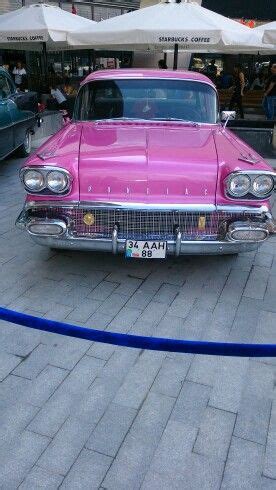 An Old Pink Car Is Parked On The Street