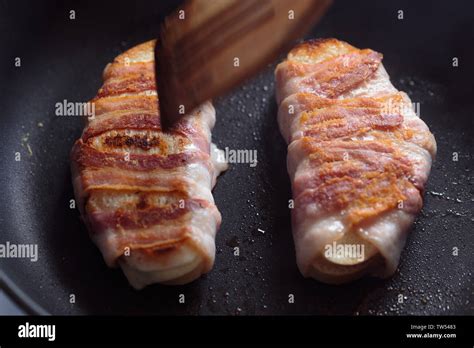 Two Slices Of A Loaf Wrapped With Fried Bacon Stock Photo Alamy