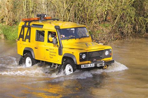 A Yellow Land Rover Driving Through Muddy Water