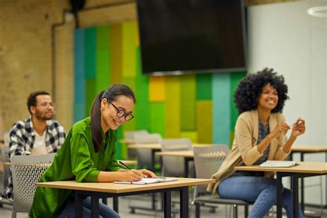 Premium Photo Group Of Young Multiracial People Sitting At Desks In