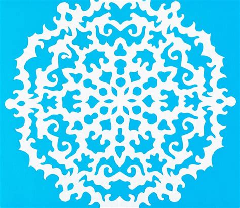 Premium Photo | White snowflake on blue paper