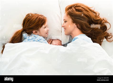 Beautiful Redhead Mother And Daughter Lying In Bed And Smiling Each