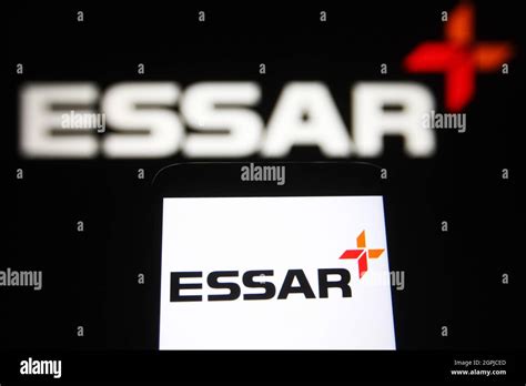 In this photo illustration an Essar Group logo is seen on a smartphone and a pc screen Stock ...