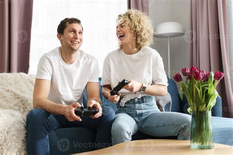 Un Couple Avec Des Manettes Joue à La Console De Jeux Vidéo à La Maison