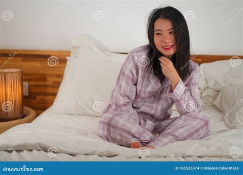 Lifestyle Portrait Of Young Beautiful And Sweet Asian Chinese Woman In Bed Feeling Happy And