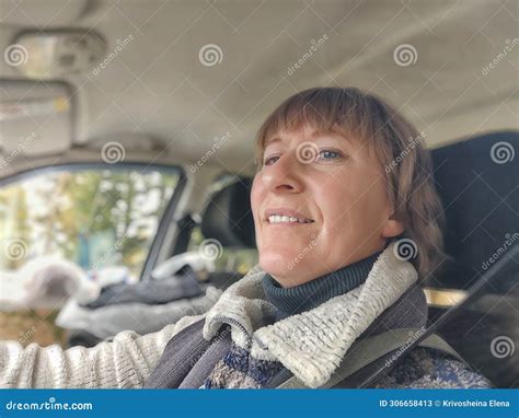 A Funny Cute Blonde Girl Or A Middle Aged Woman Driving A Car In Summer