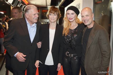 Three People Standing Next To Each Other In Front Of A Red Carpeted