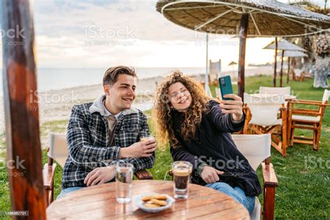 Pasangan Muda Mengambil Selfie Sambil Minum Kopi Di Bar Pantai Di