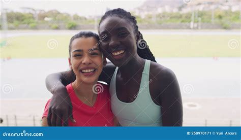 Portrait Of Female Athletes Hugging While Training Together At Stadium