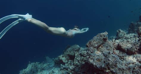 Woman With Freediving Fins Glides On Deep In Clear Ocean Freediver