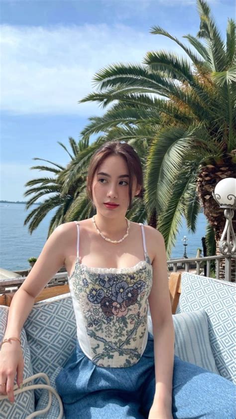 A Woman Sitting On Top Of A Blue Couch Next To Palm Trees