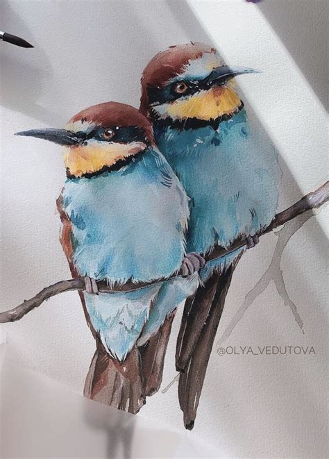 Two Blue Birds Sitting On Top Of A Branch Next To Each Other With Their