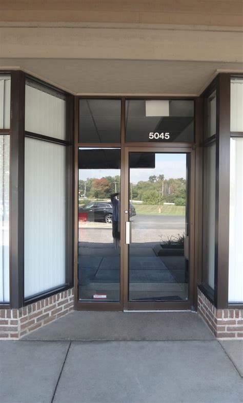 The Front Entrance To An Office Building With Glass Doors