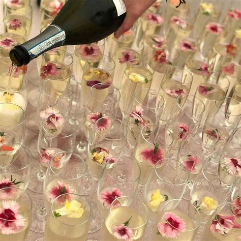 Champagne Being Poured Into Wine Glasses Filled With Flowers