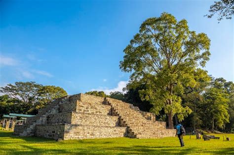 Un hombre joven viendo una pirámide maya en los templos de las ruinas