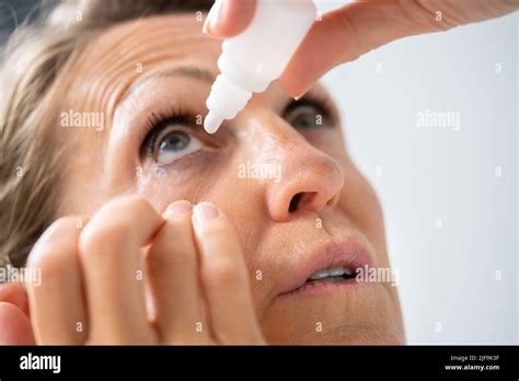 Poniendo gotas para los ojos fotografías e imágenes de alta resolución