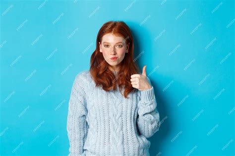 Premium Photo Sassy Redhead Girl In Sweater Looking Pleased And Showing Thumb Up Like And