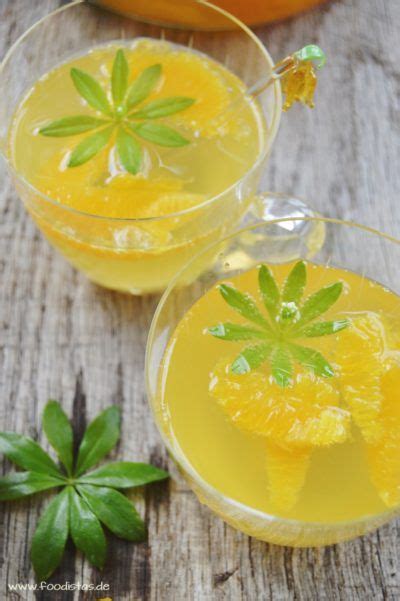 Two Glasses Filled With Orange Juice And Garnished With Leaves