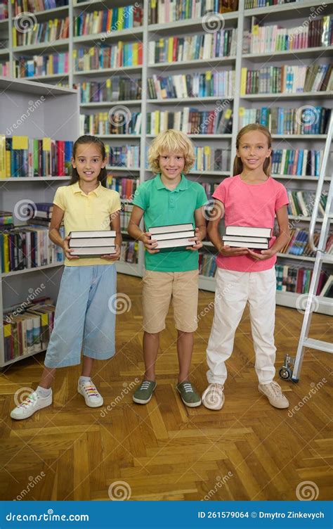 Happy Classmates Spending Time In The School Library Stock Photo