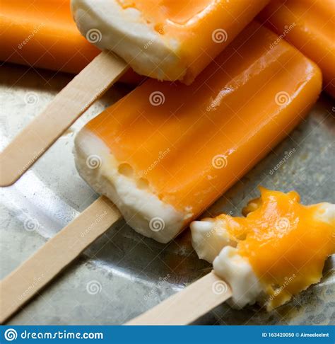 Melting Orange Creamsicles One Almost Eaten On A Galvanized Steel