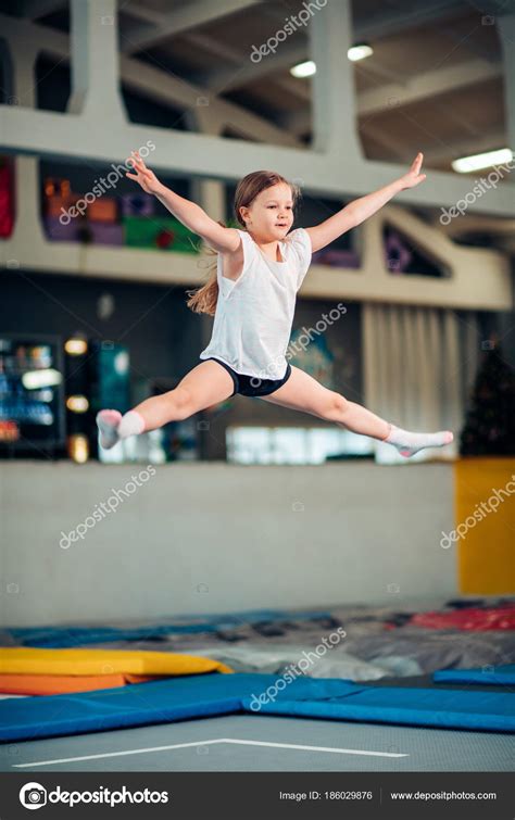 Fille sautant haut en collants rayés sur trampoline image libre de