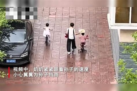 奶奶雨天带姐弟俩骑单车，全程为孙子遮雨，孙女全身都淋湿骑单车孙子孙女