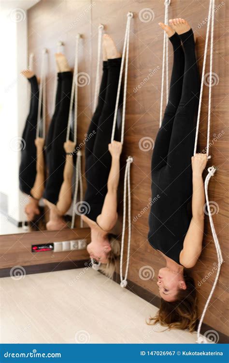 Women Hanging On Ropes Upside Down Practicing Yoga On Ropes Stretching