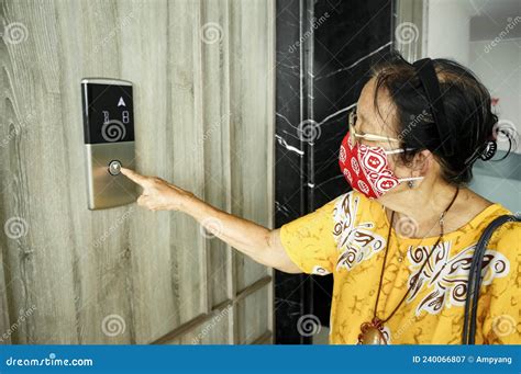 Asian Senior Woman With Cloth Face Mask Using Elevator Stock Image