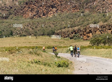 Tourists With Guide Riding Bicycles On A Dusty Road Hells Gate