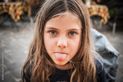 Portrait Of A Young Girl With Tongue Sticking Out Stock Photo Adobe Stock