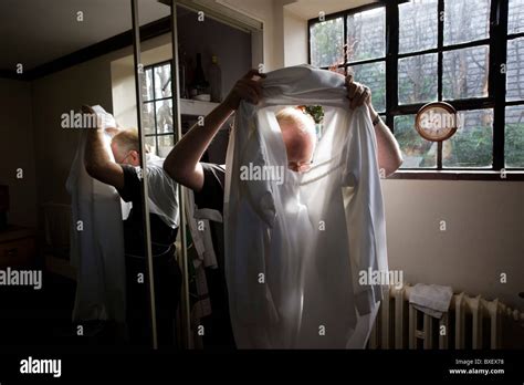 Priest Puts On His Alb Before Morning Mass In Sacristy Vestry At St