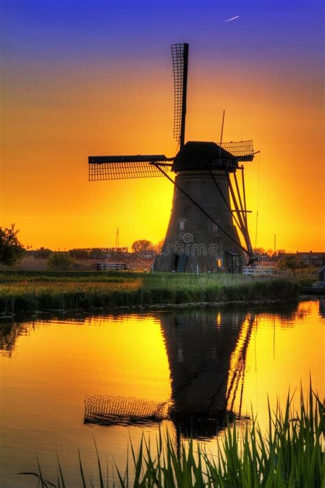 Traditional Village With Dutch Windmills And River At Sunset Holland