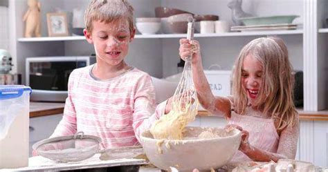 Children Making A Mess As They Bake Cake In Kitchen Together Stock