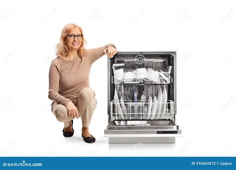 Middle Aged Woman Kneeling Next To A Dishwasher Stock Photo Image Of