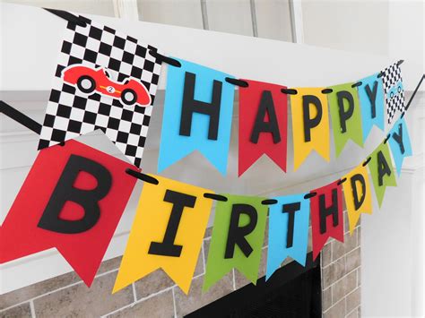 A Happy Birthday Banner Hanging From A Fireplace With Cars And