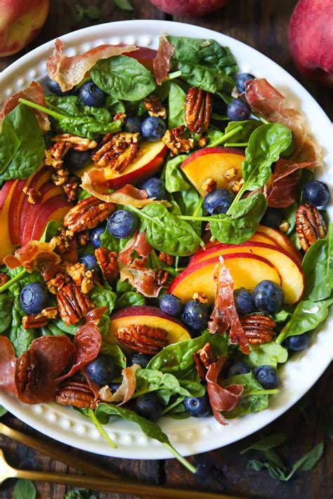 Peach Blueberry Spinach Salad With Prosciutto And Pecans In A Bowl