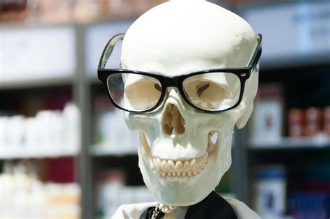 Cabeza de calavera con anteojos y bata blanca de laboratorio científico