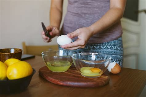 Premium Photo Womans Hands Cracking A Whole Egg Into A Bowl