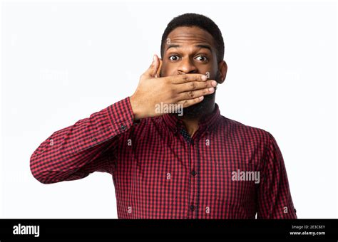 African Man Covering Mouth With Hand Posing Over White Background Stock