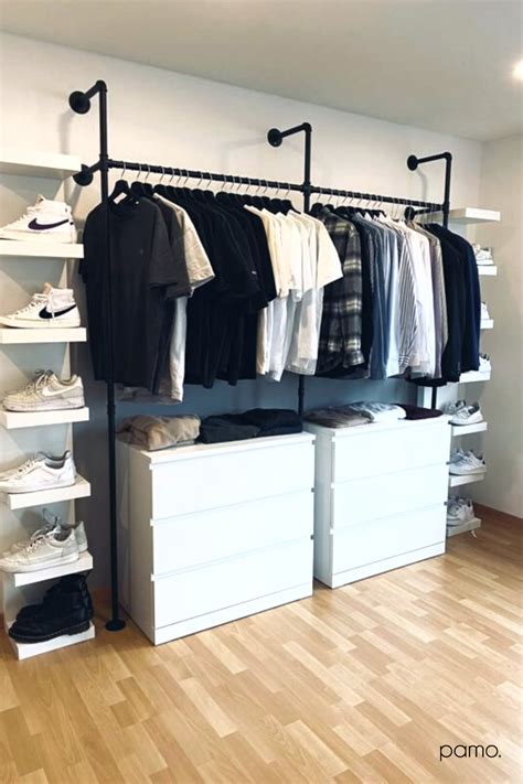 An Organized Closet With White Drawers And Clothes Hanging On The Rails