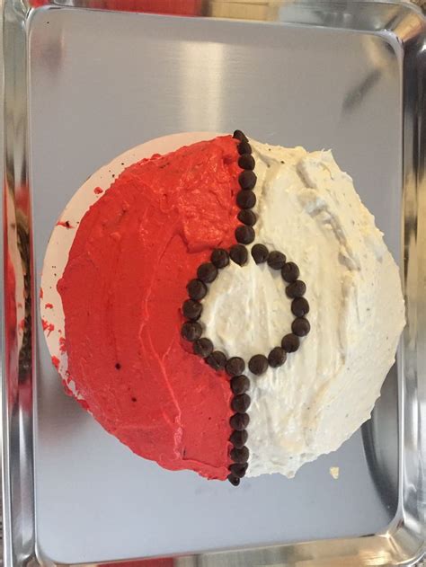 A Red Cake With White Frosting And Black Beads On It S Face Is In A Pan