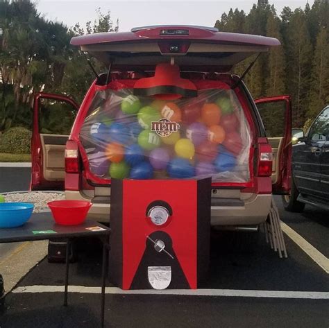 The Back End Of A Red Truck Filled With Lots Of Gummy Balls In Its Trunk