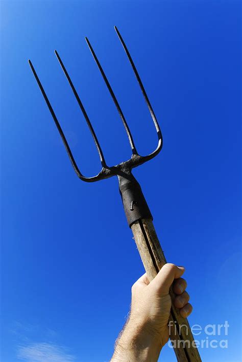 Mans Hand Holding Up Pitchfork Against Blue Sky Photograph By Sami Sarkis