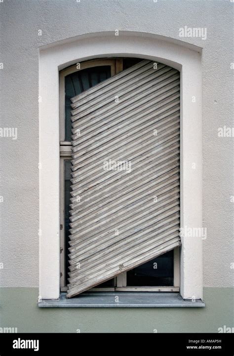 A Broken Shutter Hanging At Slanted Angle On A Window Stock Photo Alamy