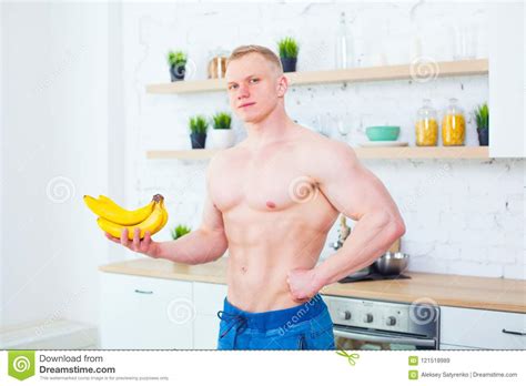 Muscular Man With A Naked Torso In The Kitchen With Fruit Concept Of Healthy Eating Athletic