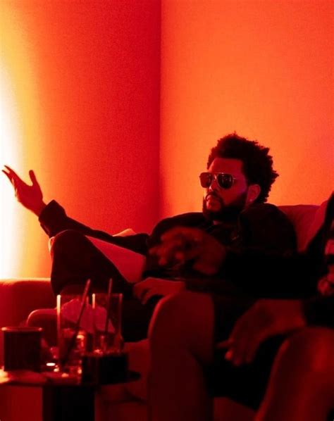 A Man Sitting On Top Of A Couch Next To A Table With Drinks In Front Of Him