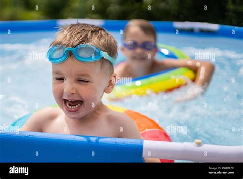 Deux garçons frères dans la piscine extérieure près de la maison nagent