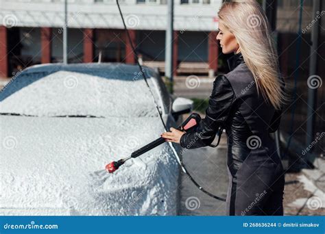 A Blonde Woman Washes A Car At A Car Wash Clean Car Water In A Hose For A Car Stock Photo